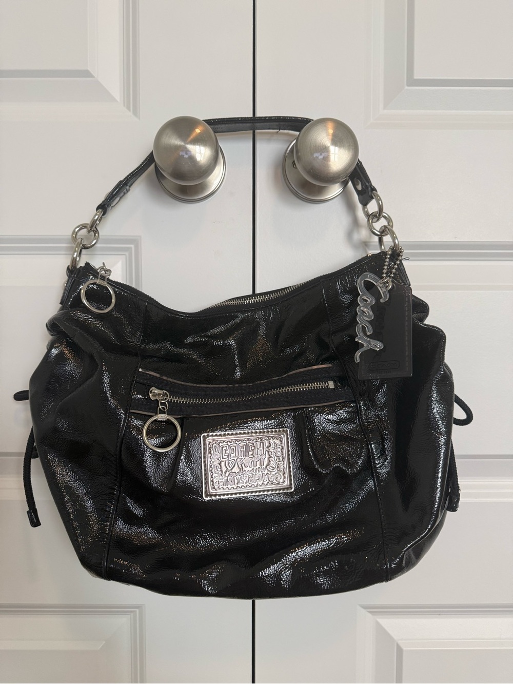 Coach Poppy Jazzy Hobo Shoulder Bag
Glossy black patent leather finish.